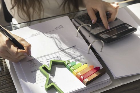 Ein Ordner auf dem ein Taschenrechner und ein Energieverbrauch zeichen liegt